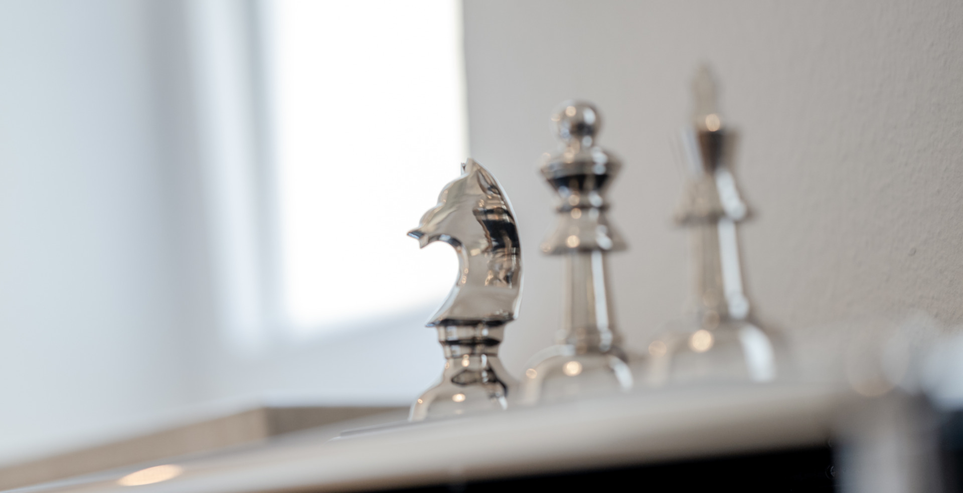 Silberne Schachfiguren als Symbol zum strategischen Vorgehen beim Aushandeln einer Abfindung